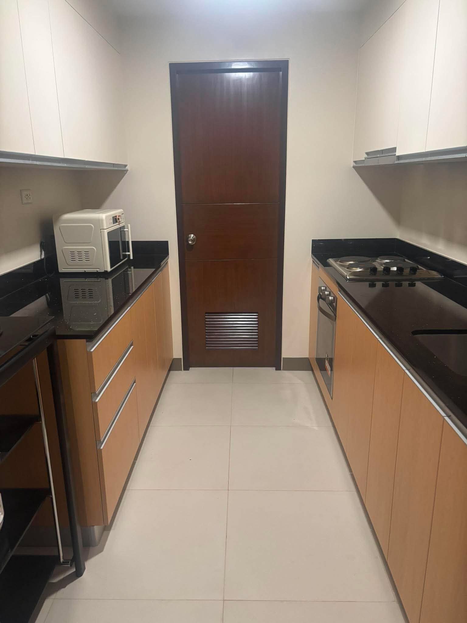Galley kitchen in the DAYON TA condo, with a gas hob, oven, and counters running the length of both walls